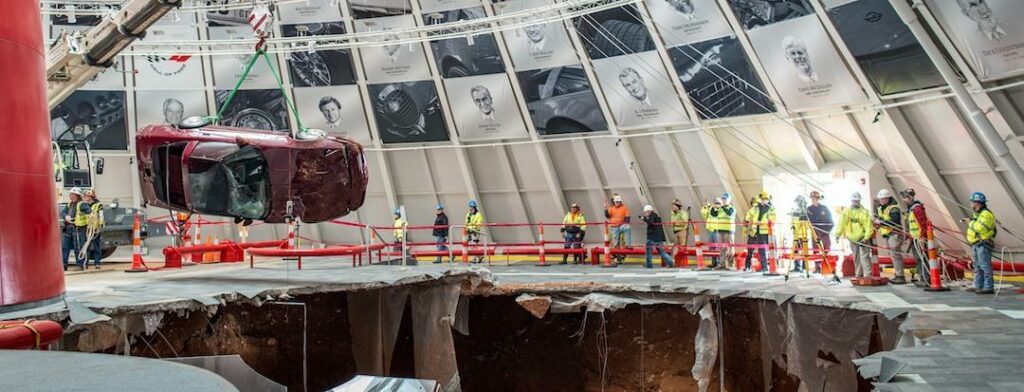 En bil höjs ut ur en håla i marken. (AI text)