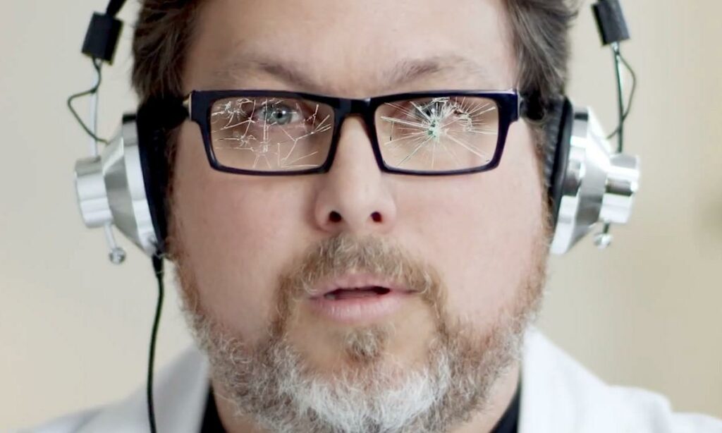 En man i labbrock och huvudlurar (AI text)