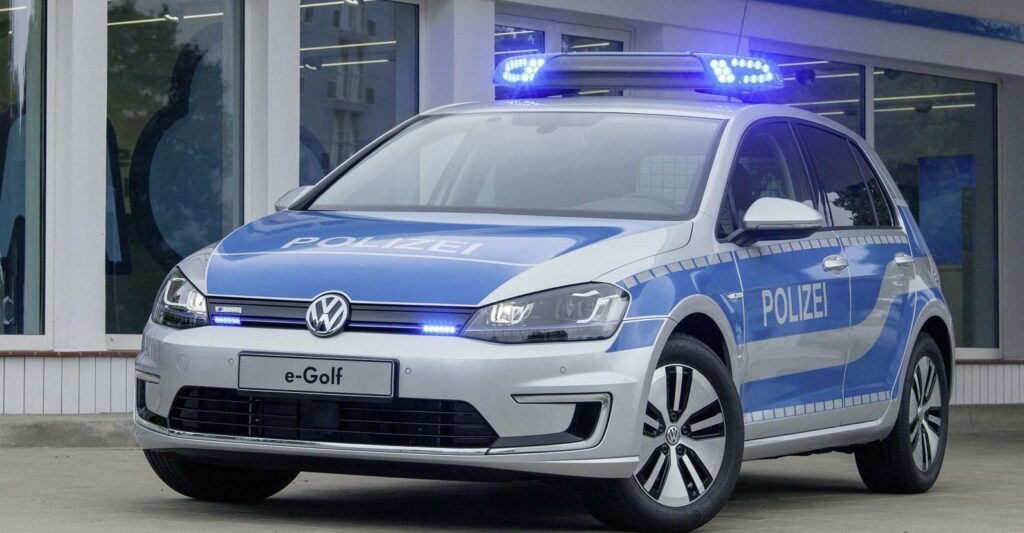 En polisbil parkerad framför ett byggnad. (AI text)