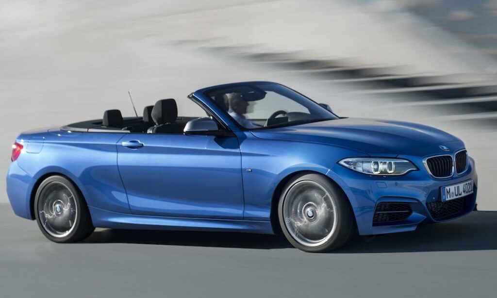 BMW 2-serien cabriolet kör nedför vägen. (AI text)