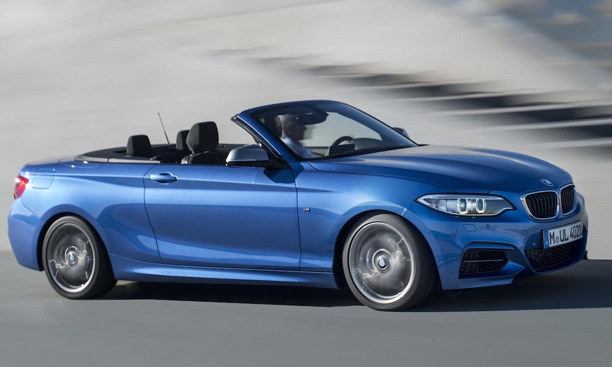 BMW 2-serien cabriolet kör nedför vägen. (AI text)