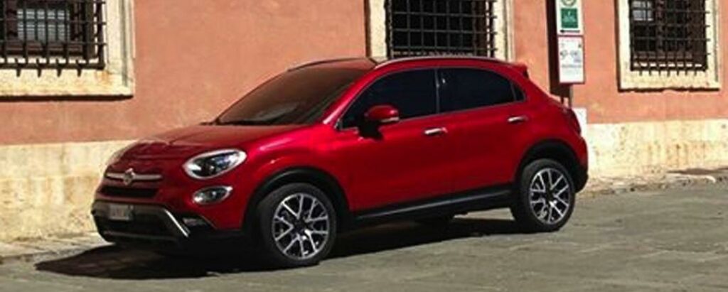 En röd Fiat SUV parkerad på en gata. (AI text)