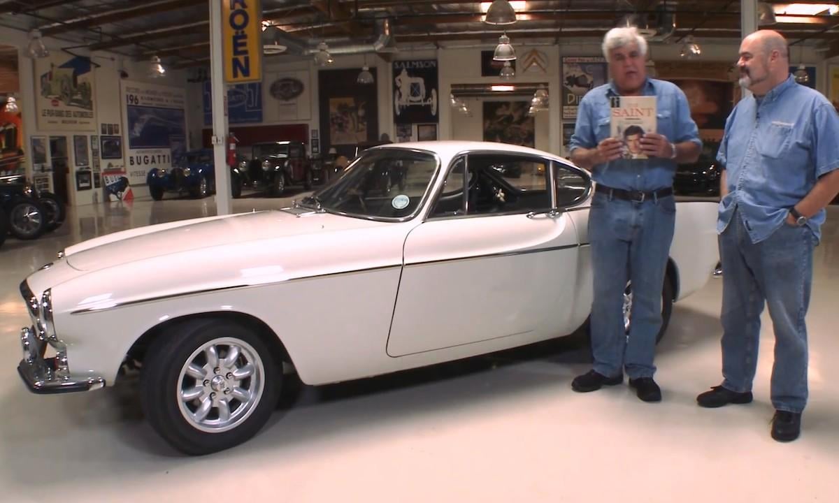 Två män står bredvid en bil. (AI text)