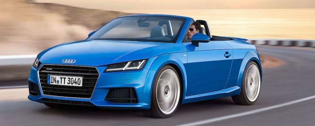 En Audi TT cabriolet kör på en väg. (AI text)