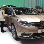 En grupp människor står omkring en bil på en bilmesse. (AI text)