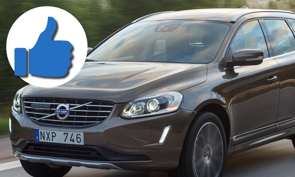 En Volvo XC90-jeep kör längs vägen med en vänlig gest. (AI text)