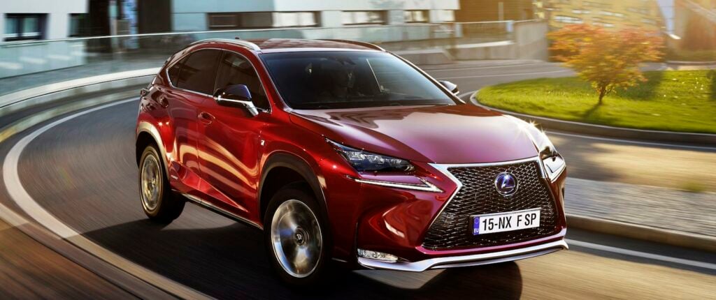 En röd Lexus-terrainvagn kör nerför en stadsgata. (AI text)