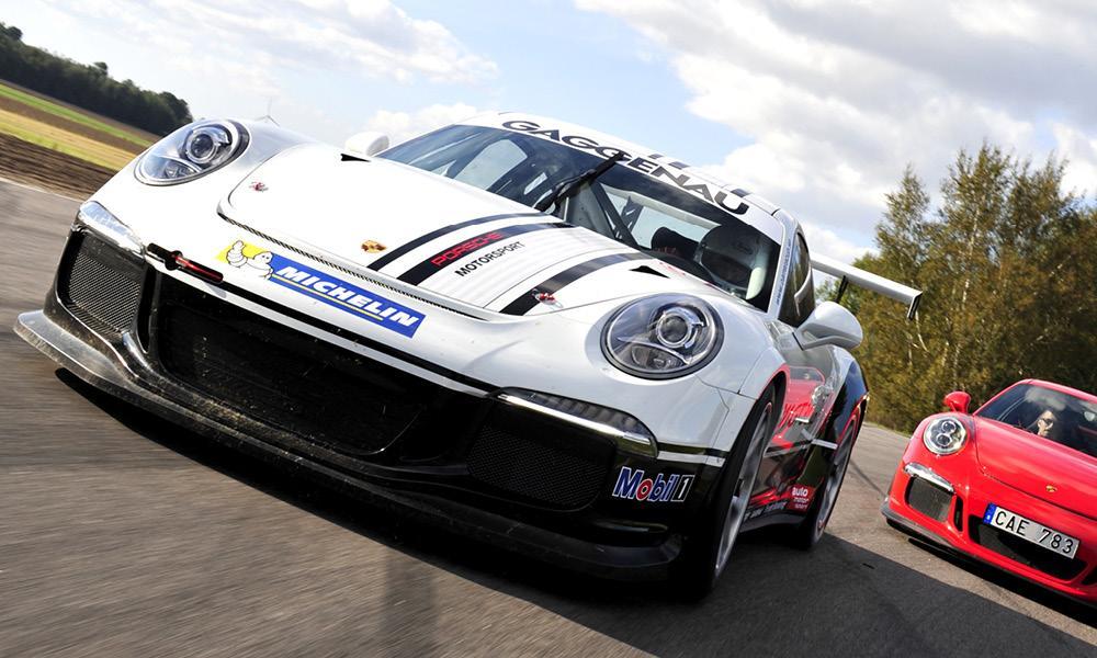 Två Porsche 911 GT3-drivingar kör på en bana. (AI text)