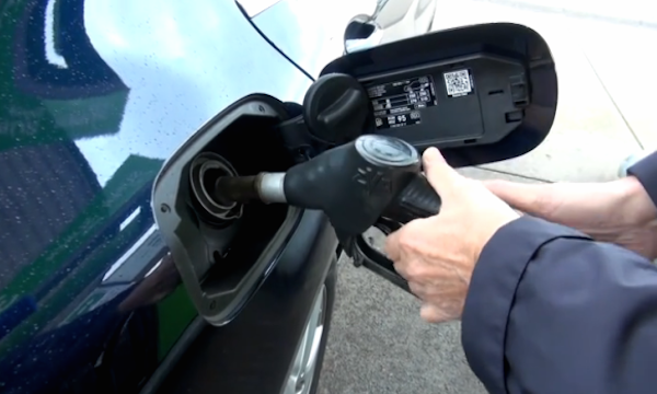 En man fyller på sin bil med bensin. (AI text)