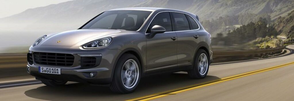 En Porsche Cayenne kör nedför en bergsväg. (AI text)