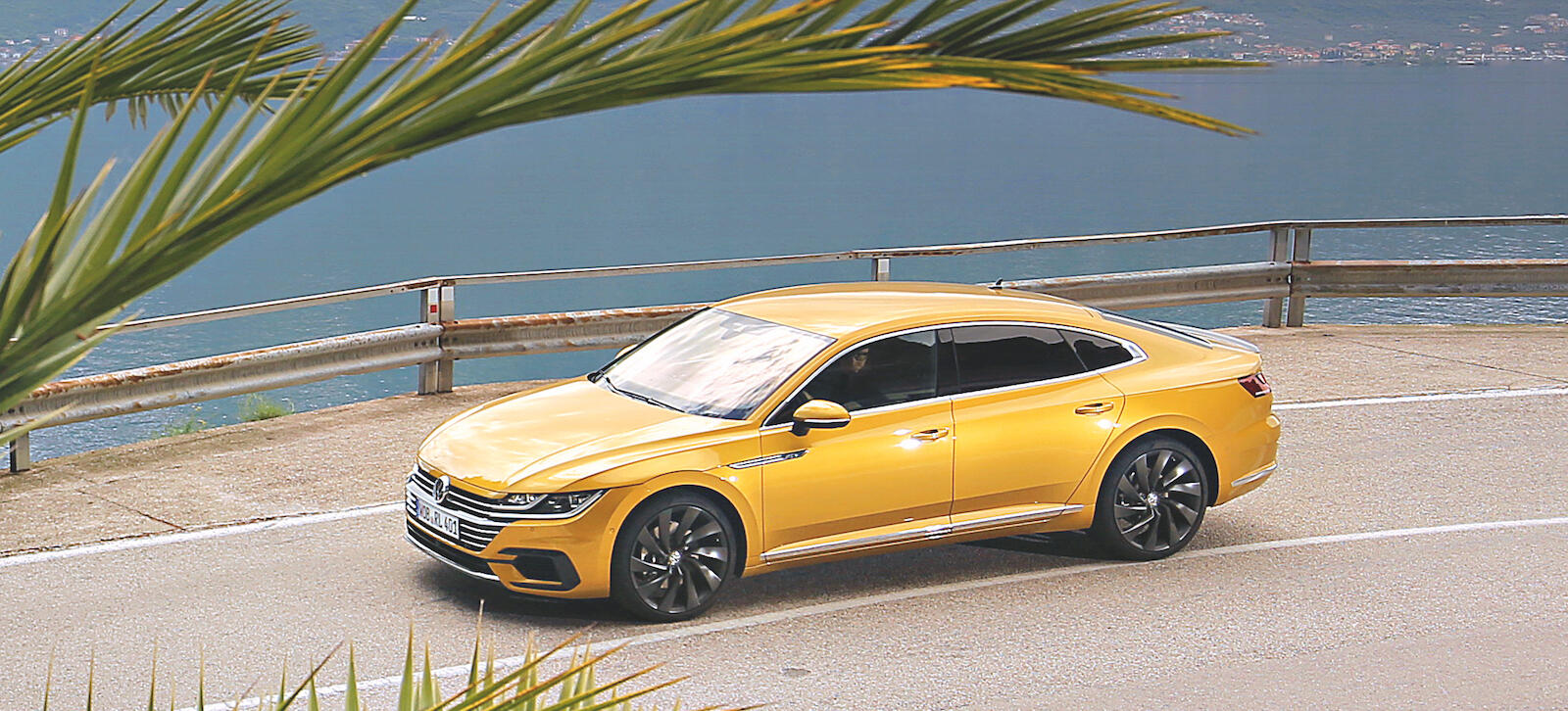 En gul Volkswagen A3 kör nedför en bergväg. (AI text)