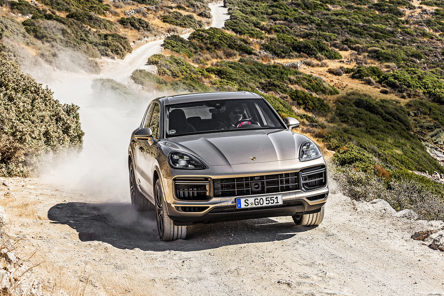 En Porsche Cayenne körer längs en grusväg. (AI text)
