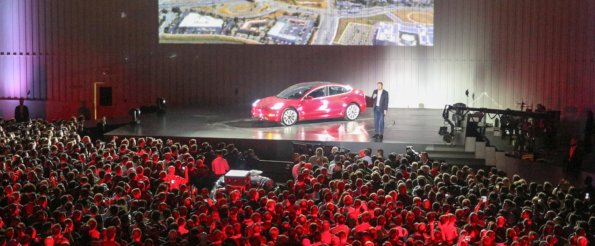 En skara människor tittar på en presentation av en bil. (AI text)