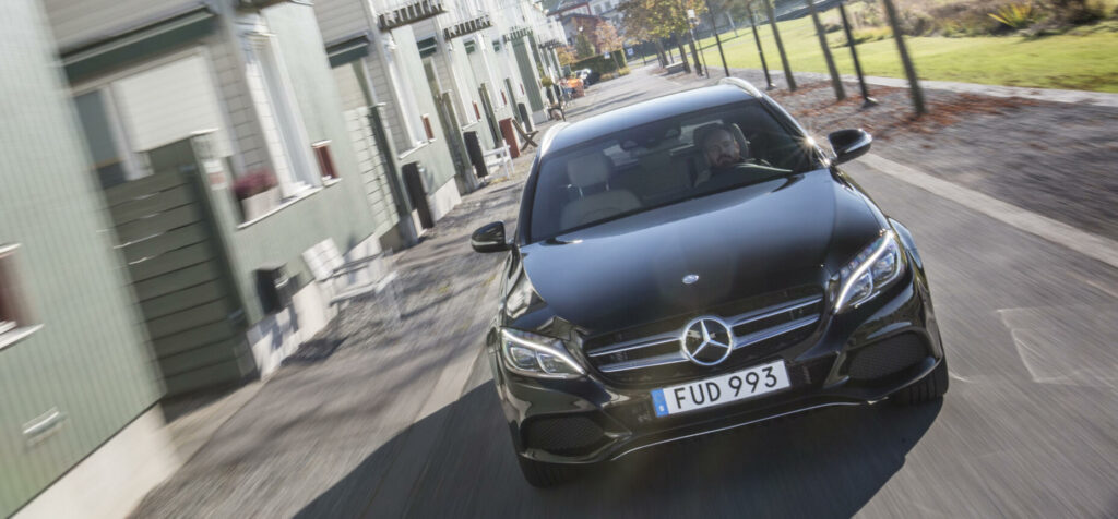 Mercedes-Benz C-klassen kör ner en gata (AI text)