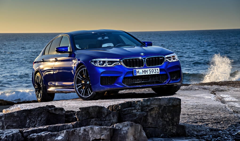 BMW M5 parkerad på klipporna vid havet (AI text)