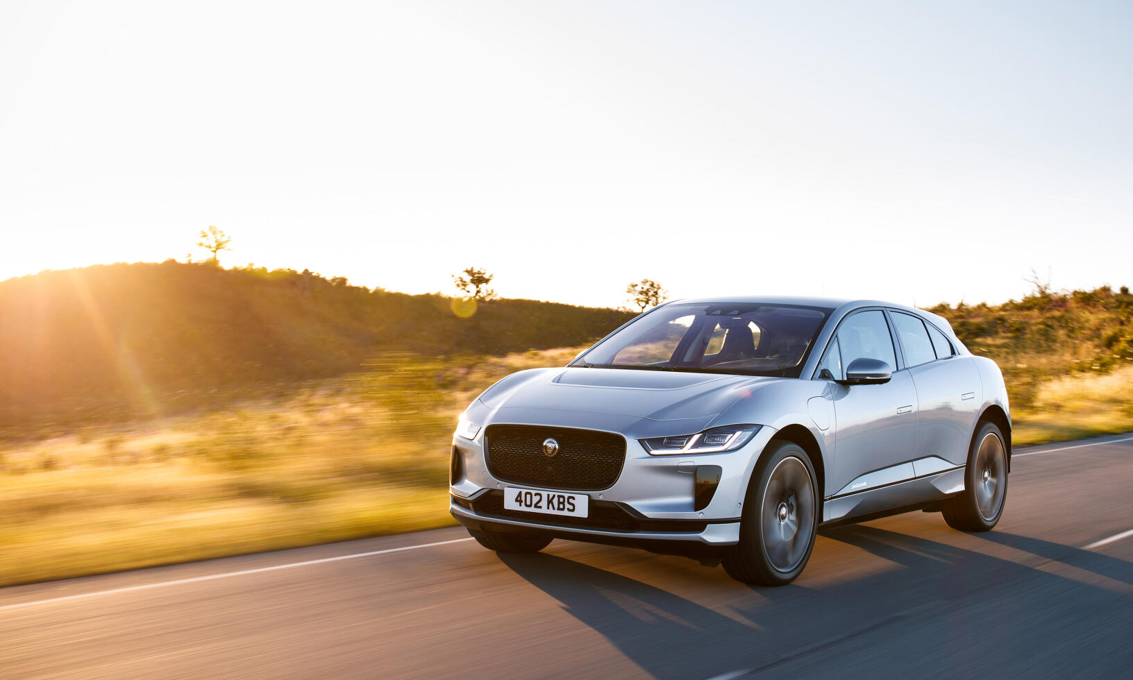 En Jaguar I Pace kör nedför en landsväg. (AI text)