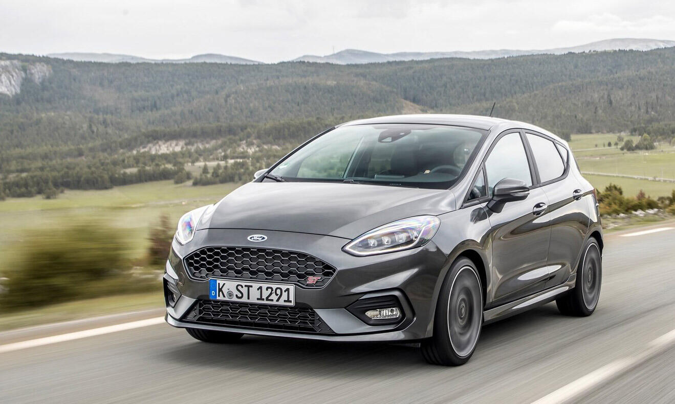 En Ford Fiesta ST kör nedför en landsväg. (AI text)