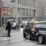 En bil står parkerad på en gata i regnet. (AI text)