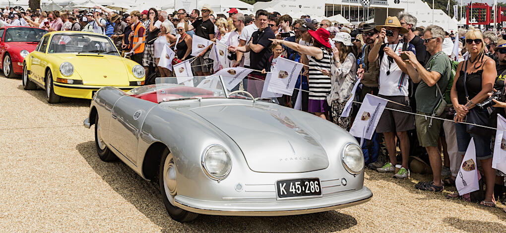 En skara människor tittar på en bilutställning. (AI text)