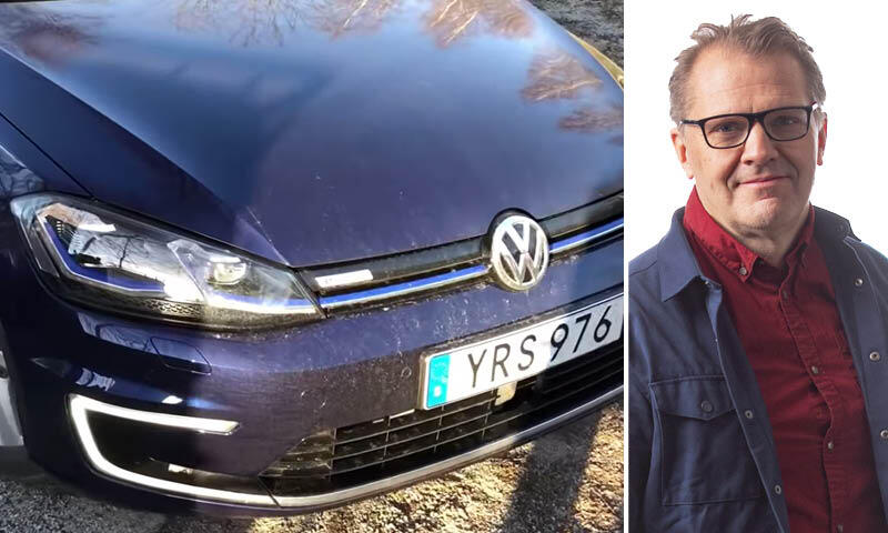 En man och en kvinna står bredvid en Volkswagen Golf E EV. (AI text)