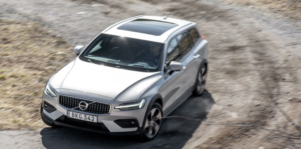 Volvo XC90 SUV kör längs en grusväg. (AI text)