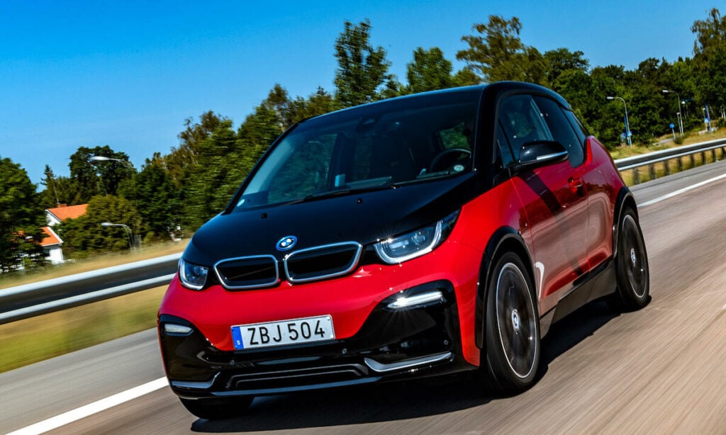 En BMW i3 kör på en landsväg. (AI text)