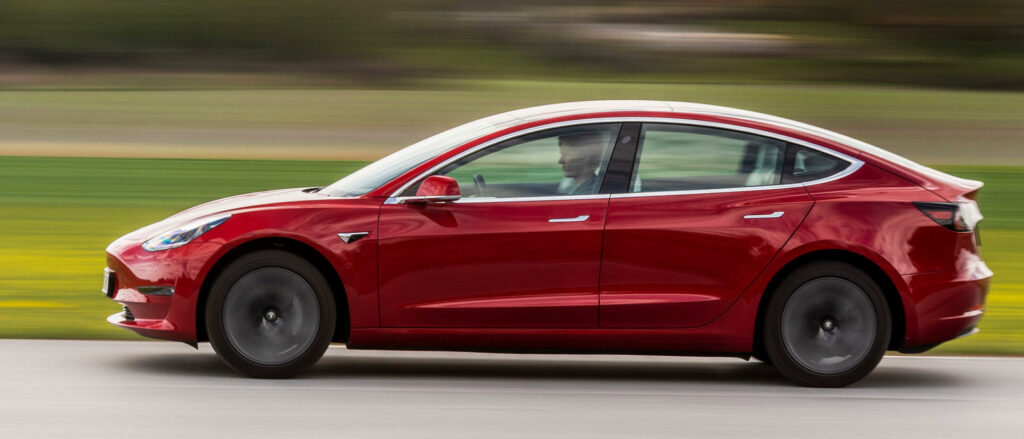 Tesla Model 3 kör på en banbana. (AI text)