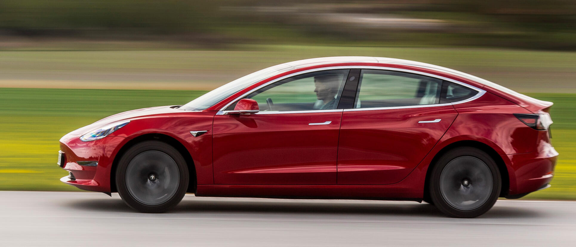 Tesla Model 3 kör på en banbana. (AI text)