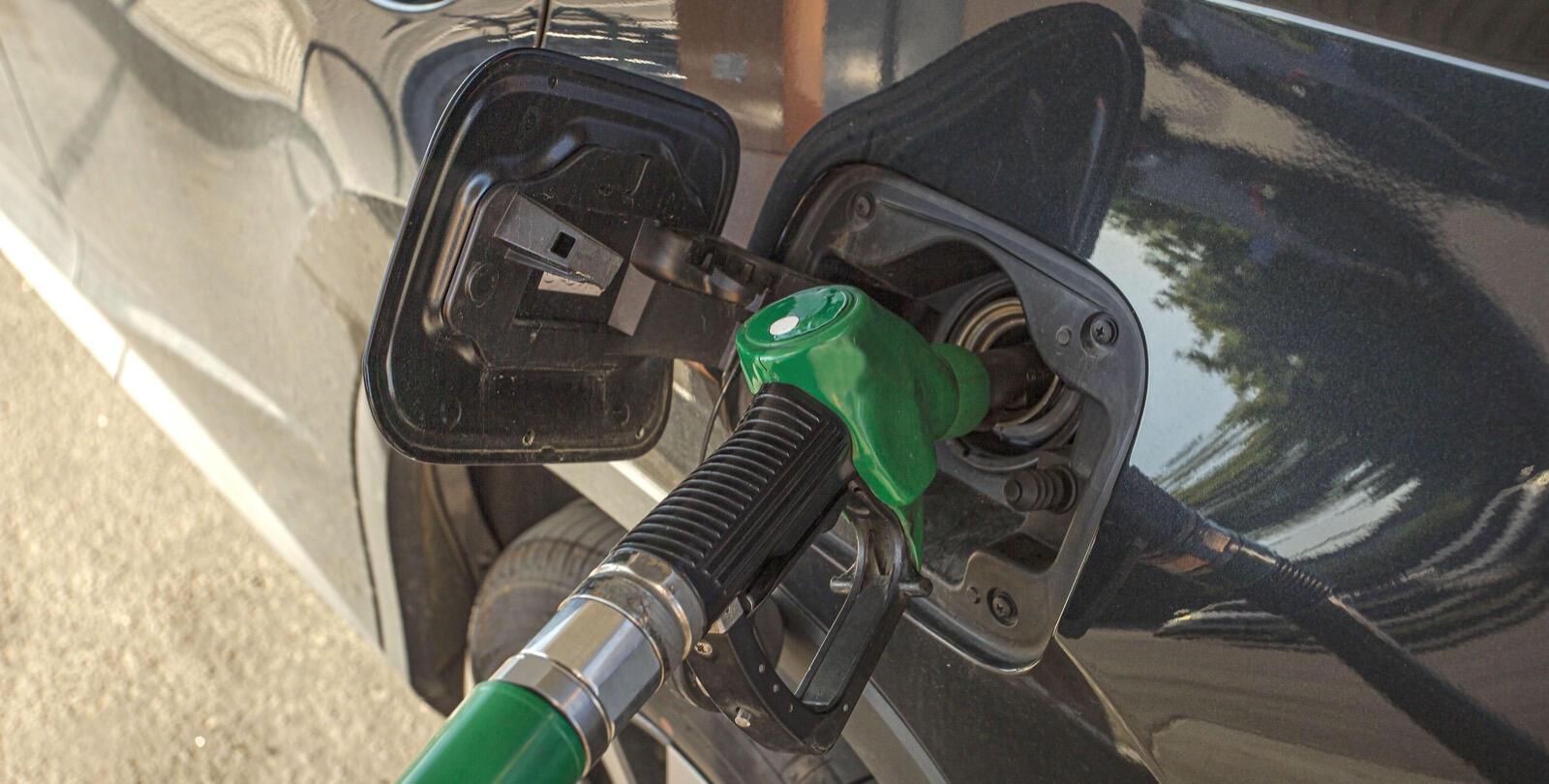 En bil tankar upp med bränsle på en bensinstation. (AI text)