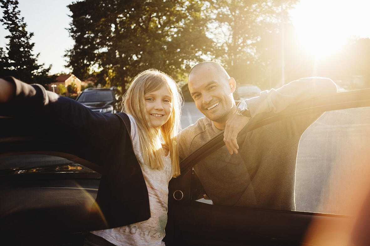 En familj står inför en bil. (AI text)