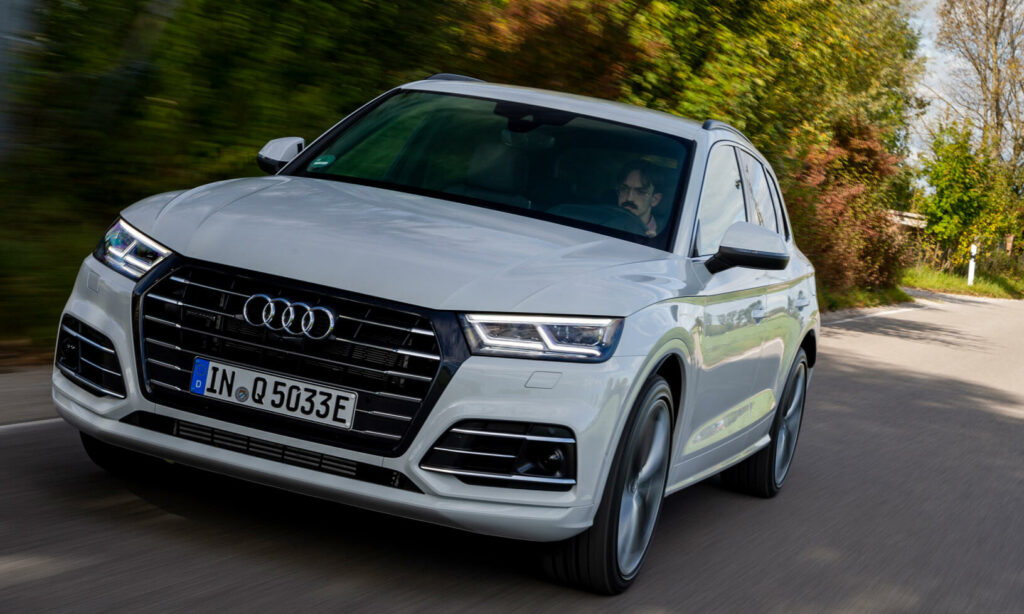 En Audi Q7 kör nerför en landsväg. (AI text)