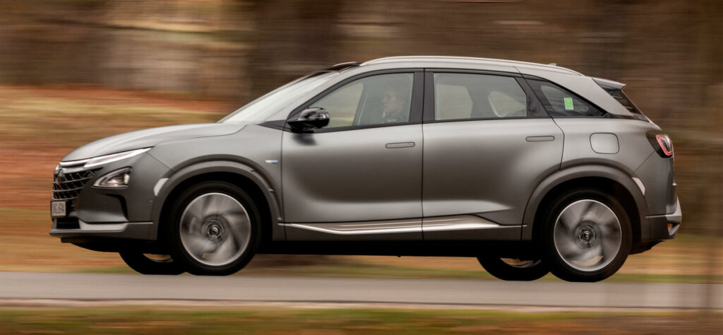 En silversvart SUV kör nerför en landsväg. (AI text)