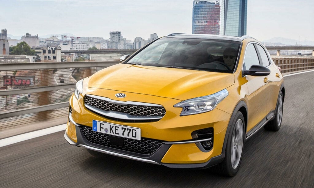 En gul Kia Rio kör på en stadsgata. (AI text)