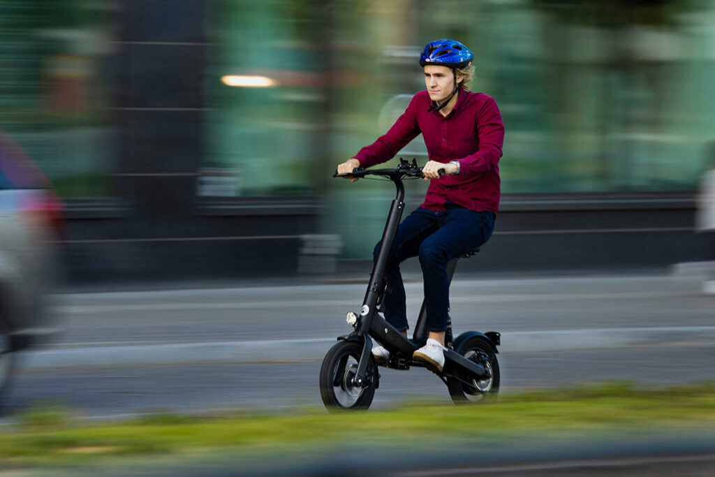 En man cyklar med en elcykel genom en stad. (AI text)