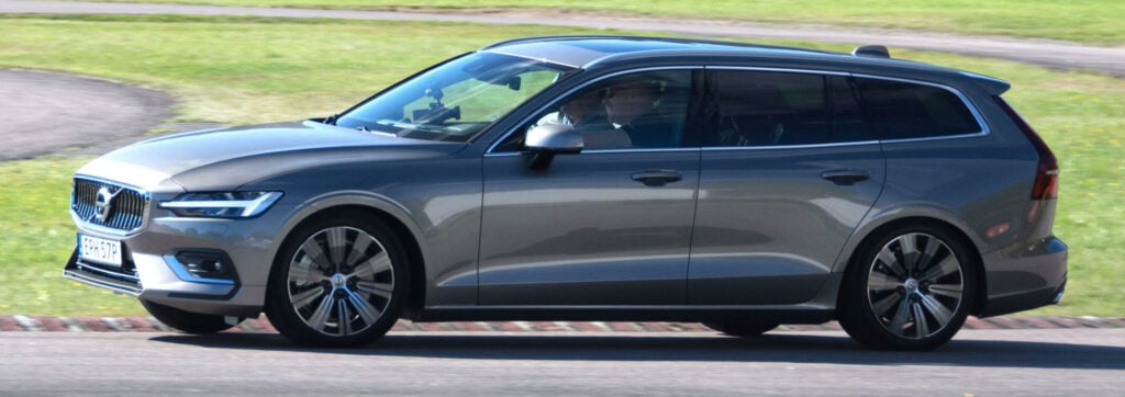 Volvo V60 kör längs en väg. (AI text)