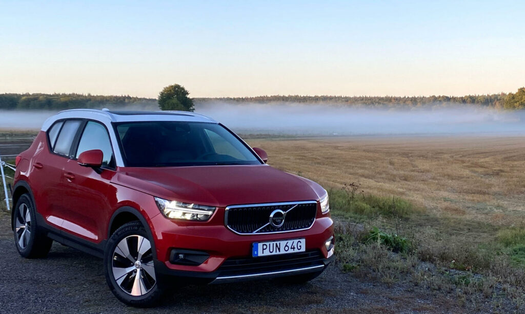 En Volvo XC90 SUV parkerad på en grusväg. (AI text)