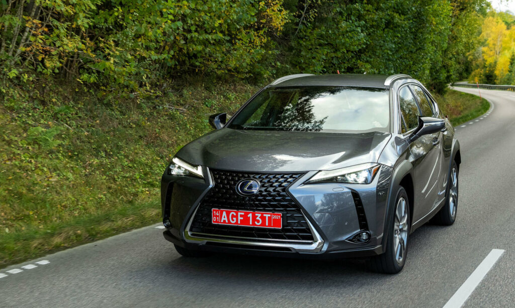Lexus NX kör längs en landsväg. (AI text)