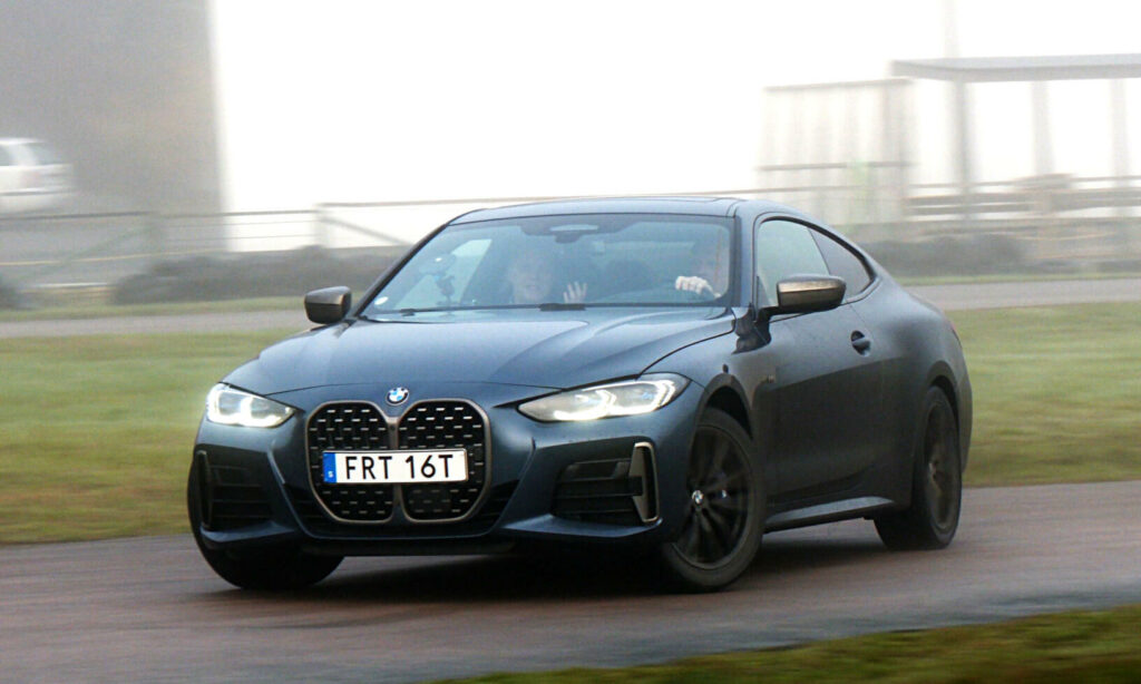 En BMW M2 Gran Coupé kör på en väg. (AI text)