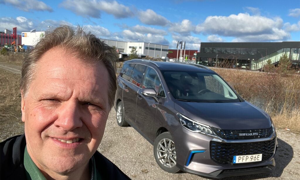 En man står framför en bil. (AI text)