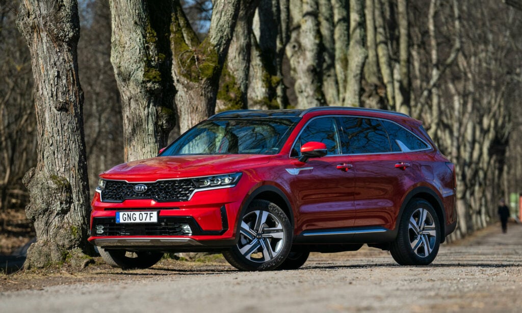 En röd Kia Sorento parkerad i en skog. (AI text)