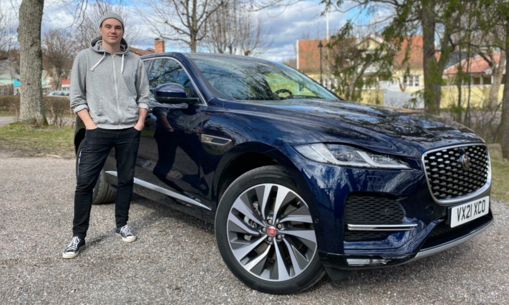 En man står bredvid en Jaguar F-Pace SUV. (AI text)