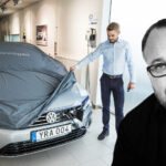 En man och en kvinna står bredvid en bil. (AI text)