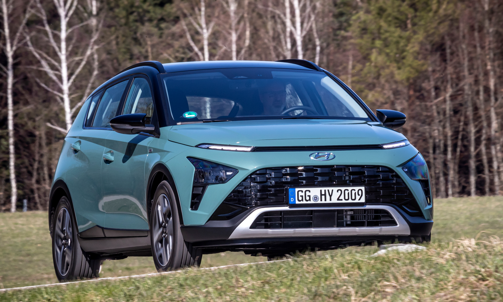 Hyundai Ioniq kör nedför en landsväg. (AI text)