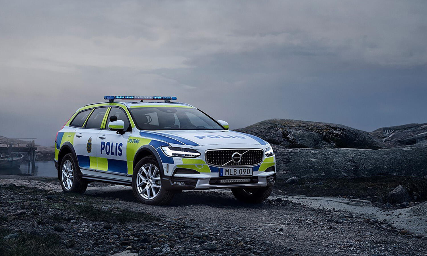 En polisbil kör på en väg med ett berg i bakgrunden. (AI text)