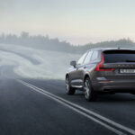 En Volvo XC90 SUV kör nedför en landsväg. (AI text)