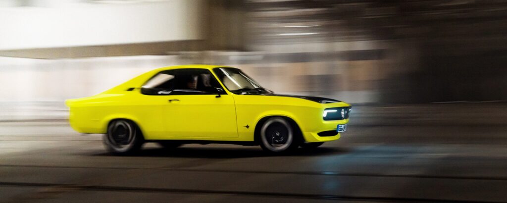 En gul bil körer ner en gata. (AI text)