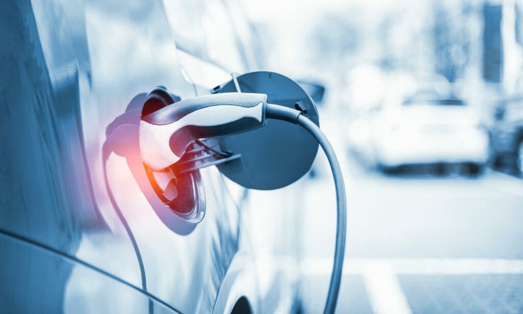 En bil är uppkopplad till en elbilsladdare. (AI text)