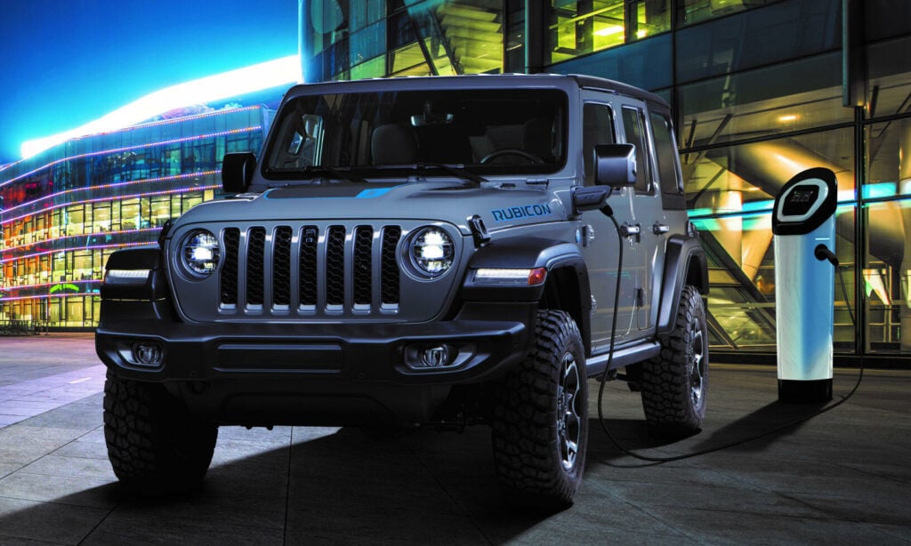 En Jeep Wrangler parkerad framför ett byggnad nattetid. (AI text)