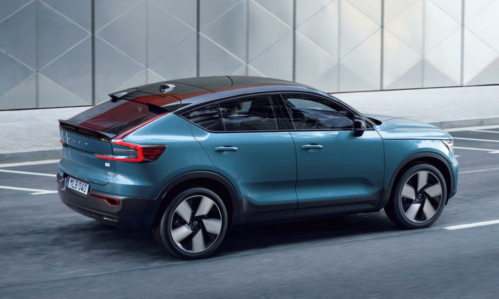 Volvo XC90-suv körs nerför gatan. (AI text)