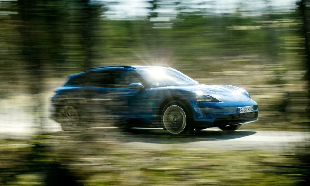 En blå Porsche Macan kör genom skogen. (AI text)